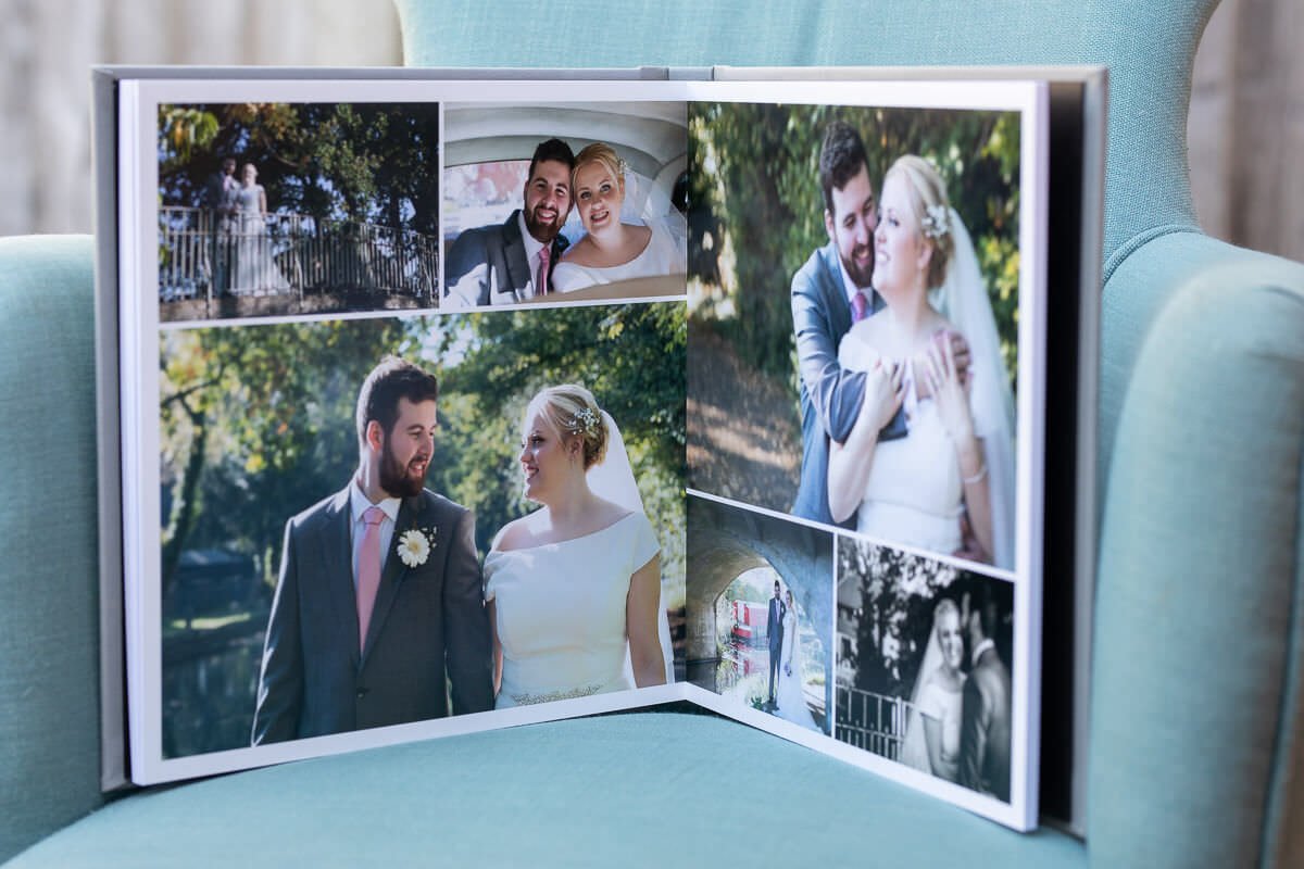 an open paged wedding album standing on a blue armchair